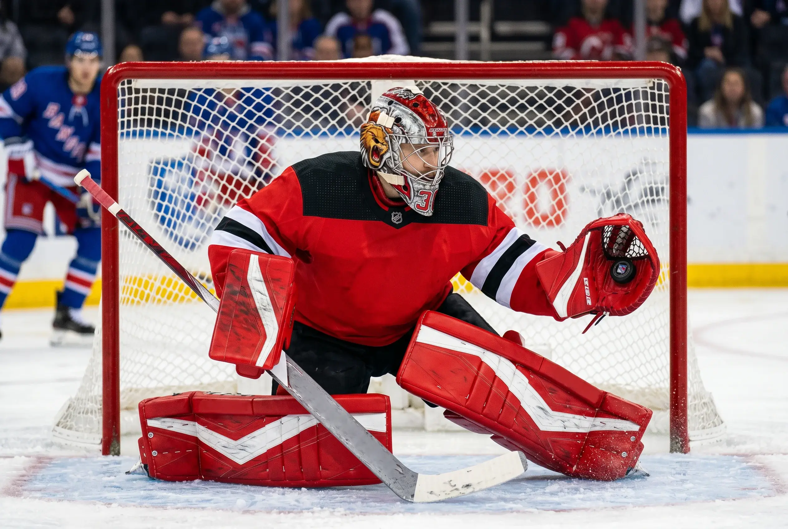 Ishockeykeeper i fuld udrustning forsvarer målet under en kamp